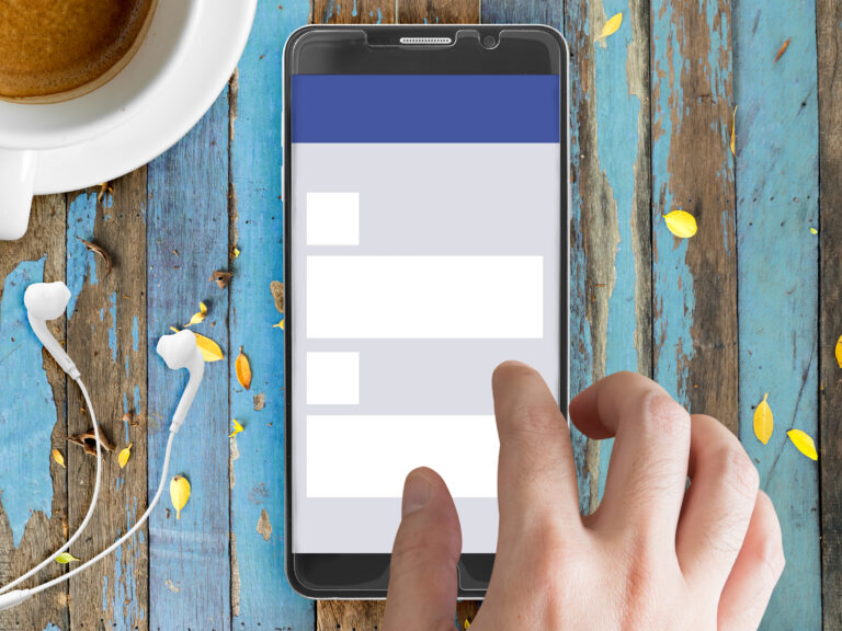 Makieta telefonu komórkowego z motywem sieci społecznościowej na ekranie i palcem.
